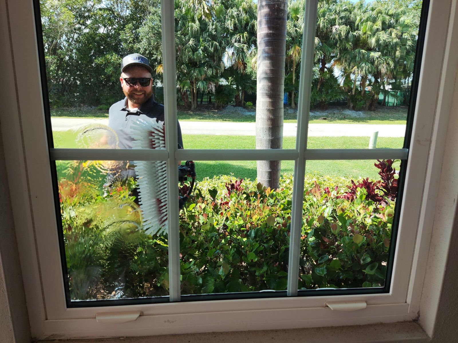 Technician using pure water system to clean exterior windows of a beachfront condo in Sebastian, Florida